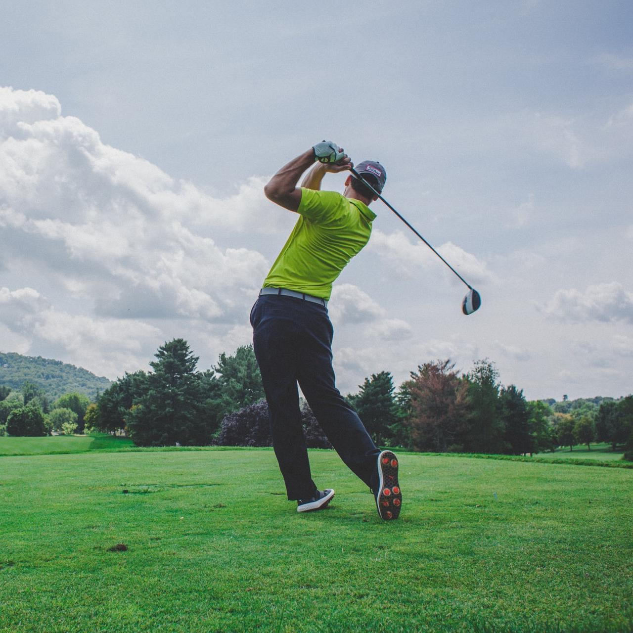 photo of man swinging golf driver